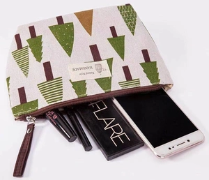 Inside view of beige canvas cosmetic bag with green Christmas tree and makeup items