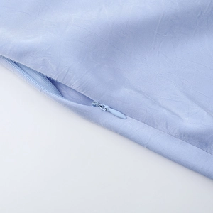 Macro view of seamless invisible zipper and fine fabric texture on light blue satin dress