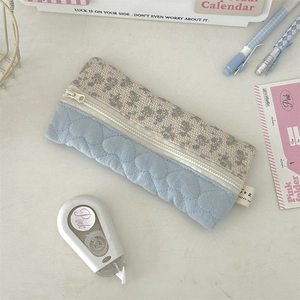 Detail van bloemen etui met blauw hartjespatroon en diverse kantoorbenodigdheden