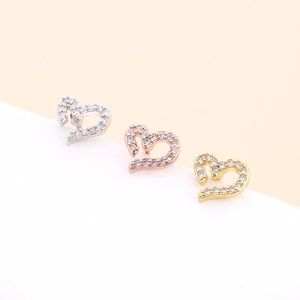 Detailed view of three heart shaped studs in silver, gold and rose gold with zircon stones