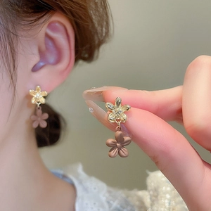 Detail of elegant double floral drop earrings in gold and mocha brown matte finish