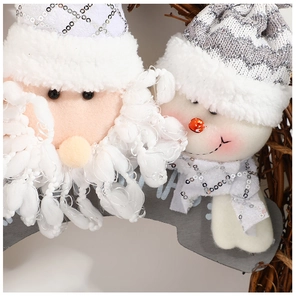 Detail of plush Santa and Snowman ornaments with sequins on a natural rattan wreath