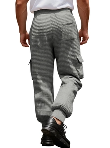 Detail of grey waffle knit cargo pants featuring ribbed waist and large flap pockets