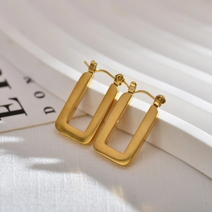 Detailed close-up of rectangular geometric hoop earrings with a gold brushed metal finish