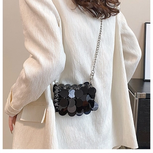 Chic black sequin crossbody bag shown on a model with metallic chain shoulder strap