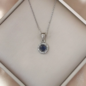 Macro view of sapphire blue pendant necklace with sparkling white zircons on silver chain
