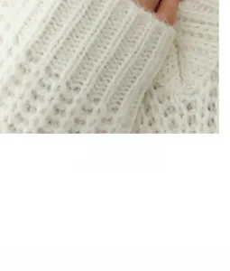 Détail du poignet côtelé d'un pull en maille mohair blanche avec une texture douce et veloutée