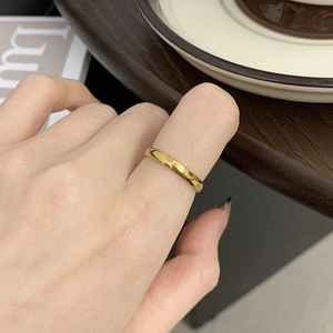 Close-up of minimalist 18K gold plated celestial ring worn on a finger in a cozy setting