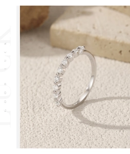 Macro detail of S925 sterling silver half eternity ring with moissanite stones on beige stone