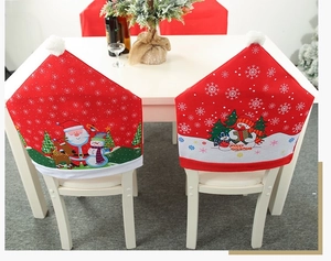 Detail of red Christmas chair covers with Santa and snowman prints on white chairs