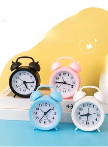 Detailed view of colorful silent bedside alarm clocks in matte pink, blue, black and white