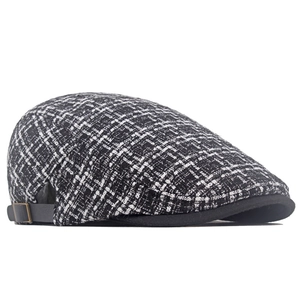 Dettaglio del cappello in tweed con cinturino in pelle nera e fibbia in metallo bronzo