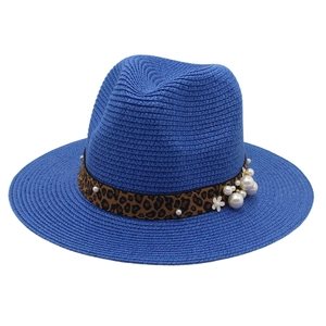 Detail of navy straw hat featuring leopard print ribbon with pearls and flower accents