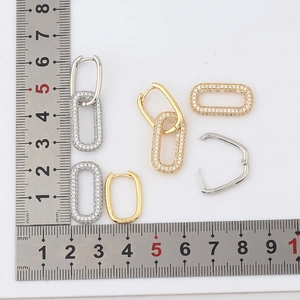 Gold and silver geometric oval link earrings with cubic zirconia shown with a ruler