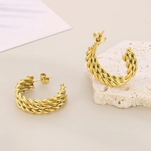 French vintage gold twisted C-shape stainless steel earrings on a textured stone base