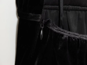 Dettaglio della cerniera invisibile e della texture del tessuto in velluto nero