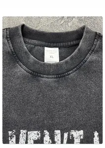 Dettaglio del collo a costine con stampa vintage screpolata su t-shirt grigia