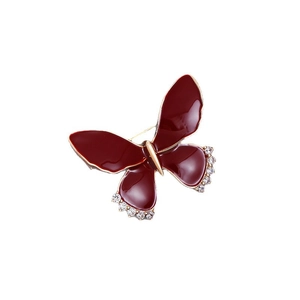 Elegant gold butterfly brooch with deep red enamel wings and sparkling rhinestones