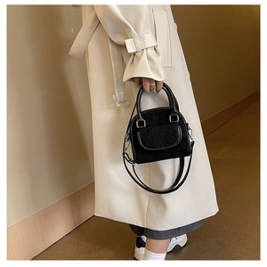 Chic black shell handbag with faux fur patchwork details and silver hardware