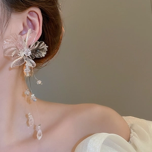 Close-up of elegant clear floral tassel earrings worn by a model in a side view profile