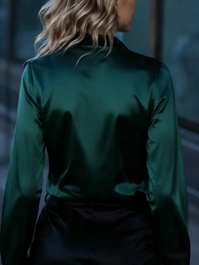 Detailed back view of a glossy dark green satin long sleeve shirt with elegant drape
