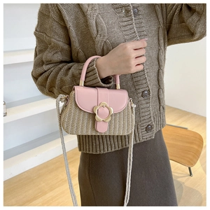 Détail du sac en paille avec rabat en cuir rose et fermoir fleur en métal doré