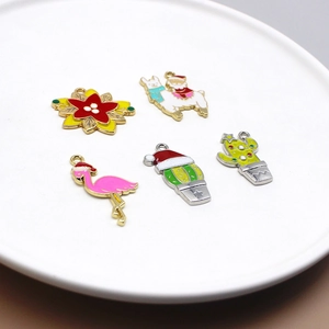 Detail of Christmas alloy charms with flamingo and cactus on a white ceramic plate