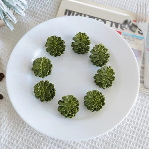 Set of 8 green artificial pine cones on a white ceramic plate for Christmas decor