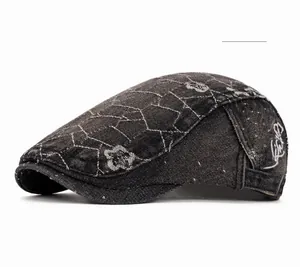 Detail of grey washed denim beret featuring diamond pattern and floral embroidery accents