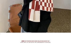 Close-up of red and white checkerboard knit scarf on model for soft texture detail