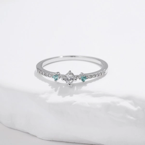 Elegant s925 silver ring with a white round center stone and blue side gemstones