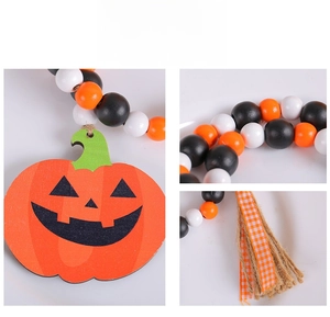 Dettaglio macro di ghirlanda di perle di legno di Halloween con zucca e nappa di iuta