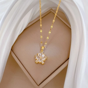 Close-up of gold titanium necklace with double-layer zircon flower pendant on silk