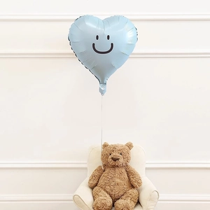 Light blue heart-shaped smiley face balloon floating above a cute brown teddy bear