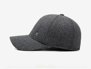 Détail de la texture tricotée gris foncé et du logo R en métal argenté sur la casquette hiver