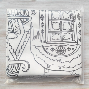 DIY coloring pillowcase with garden patterns in clear retail packaging on wood background