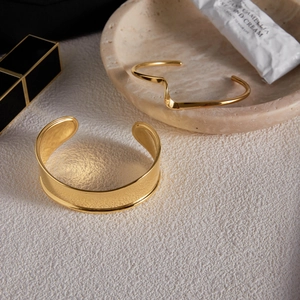Gros plan de bracelets joncs ouverts en acier inoxydable plaqué or 18 carats élégants