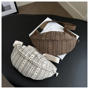 Detail of corduroy waist bags in brown and beige with textured stripes and buckles