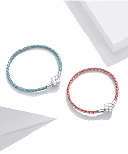 Detail of woven leather bracelets in mint and pink with silver clover clasps