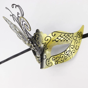 Macro detail of laser-cut butterfly masquerade mask with gold glitter and black filigree
