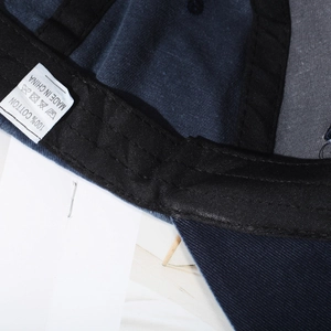 Internal view of washed navy cotton baseball cap with sweatband and care label details