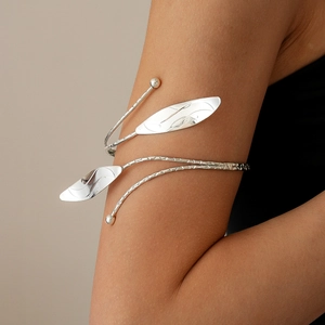 Macro shot of silver leaf arm cuff featuring polished metal leaves and minimalist beads