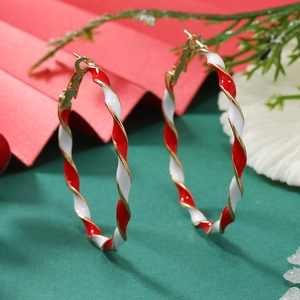 Detail of red and white candy cane striped hoop earrings with festive pine decor