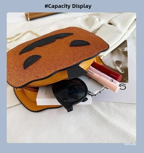 Detail view of pumpkin crossbody bag capacity showing sunglasses and lipsticks inside
