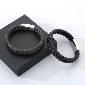 Detail of woven leather bracelets in black and brown with polished stainless steel magnetic clasps