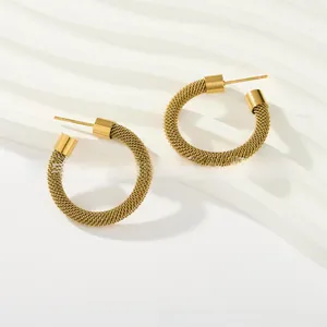 Detailed close-up of woven gold titanium steel hoop earrings with textured mesh pattern