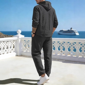 Men's dark gray linen hooded suit shown from the back on a sunny seaside balcony