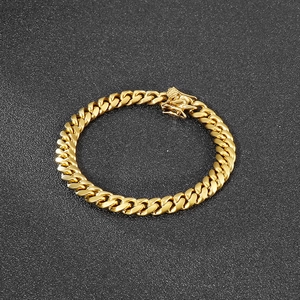 Golden 8mm Cuban link chain bracelet with secure box clasp on a textured background