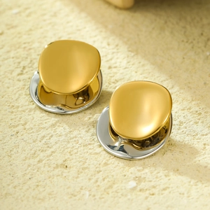 Polished two-tone gold and silver geometric stainless steel earrings on textured surface