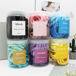 Dettaglio di sei elastici colorati per capelli in vasetti trasparenti minimalisti